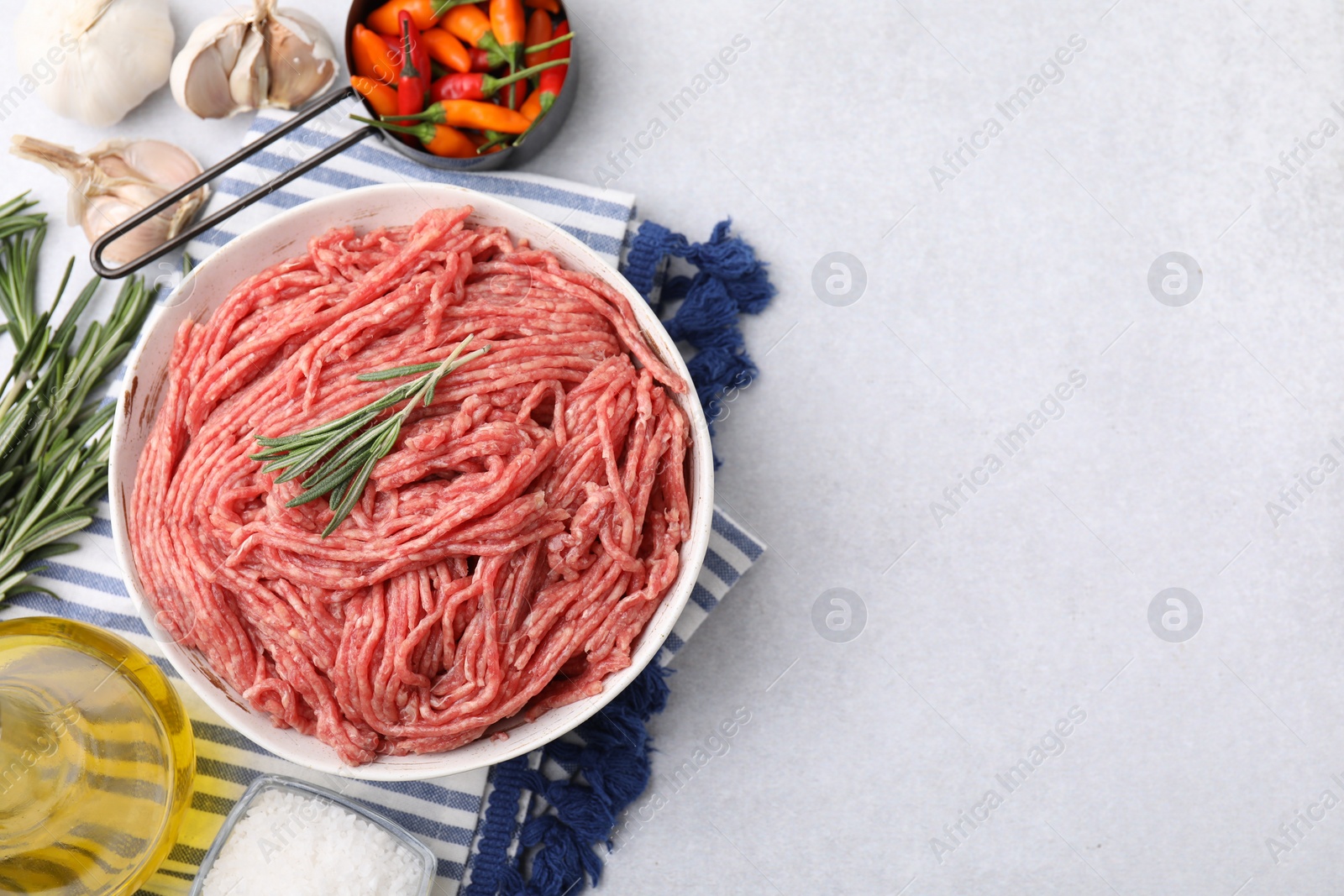 Photo of Flat lay composition with fresh raw ground meat on light table. Space for text