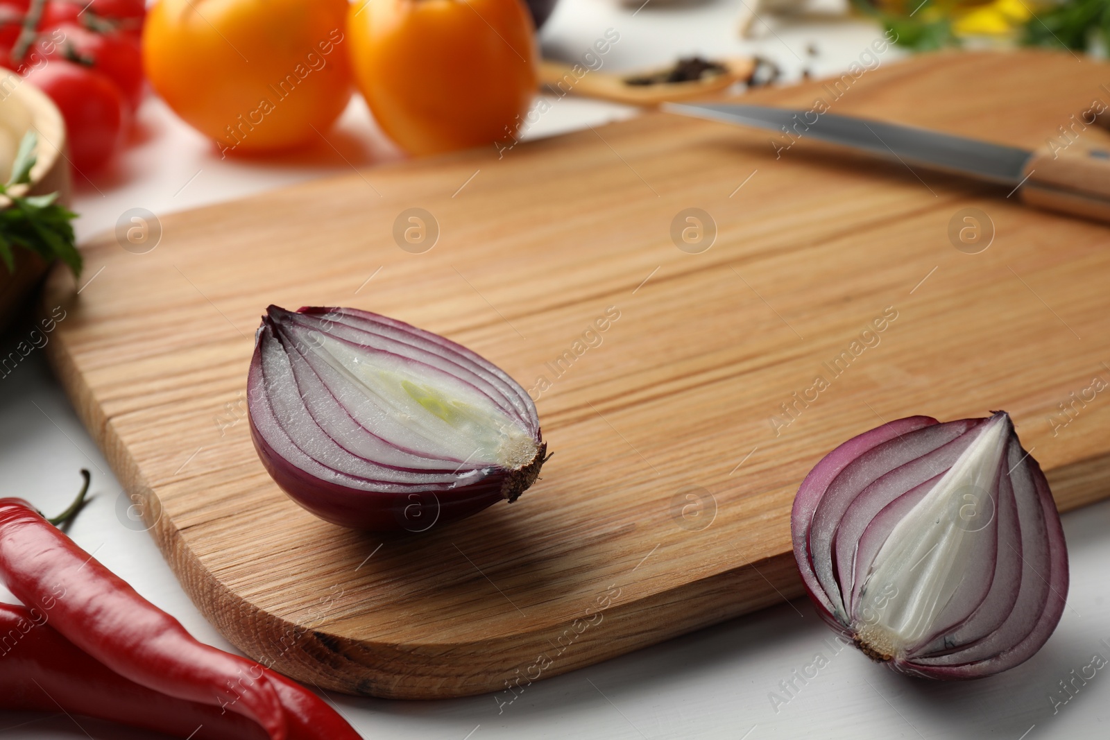 Photo of Cutting board with different vegetables and knife on white wooden table, closeup