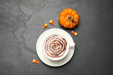 Photo of Flat lay composition of coffee with spider's net latte art on grey table. Halloween celebration