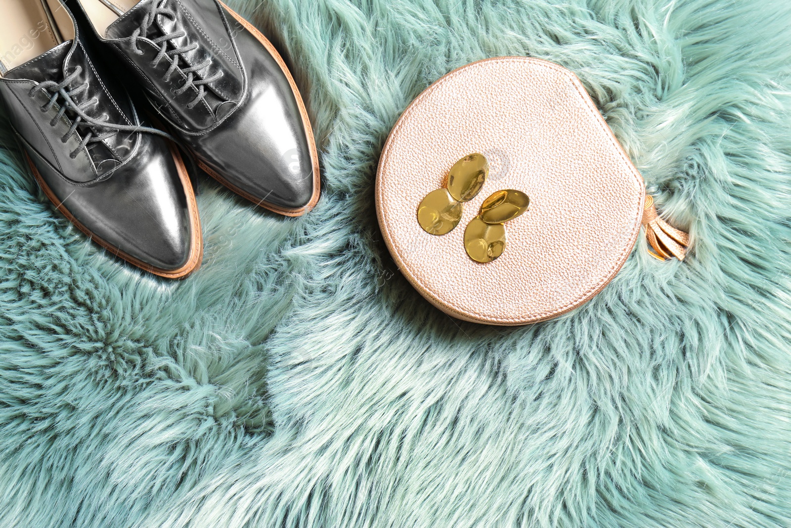 Photo of Pair of lady's shoes and bag on fluffy plaid, top view with space for text