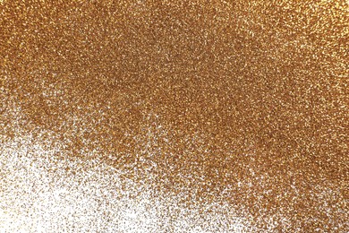 Photo of Shiny golden glitter on white background, top view