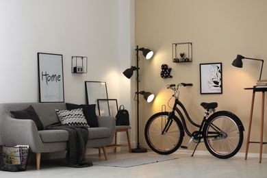 Photo of Modern living room interior with comfortable sofa and bicycle