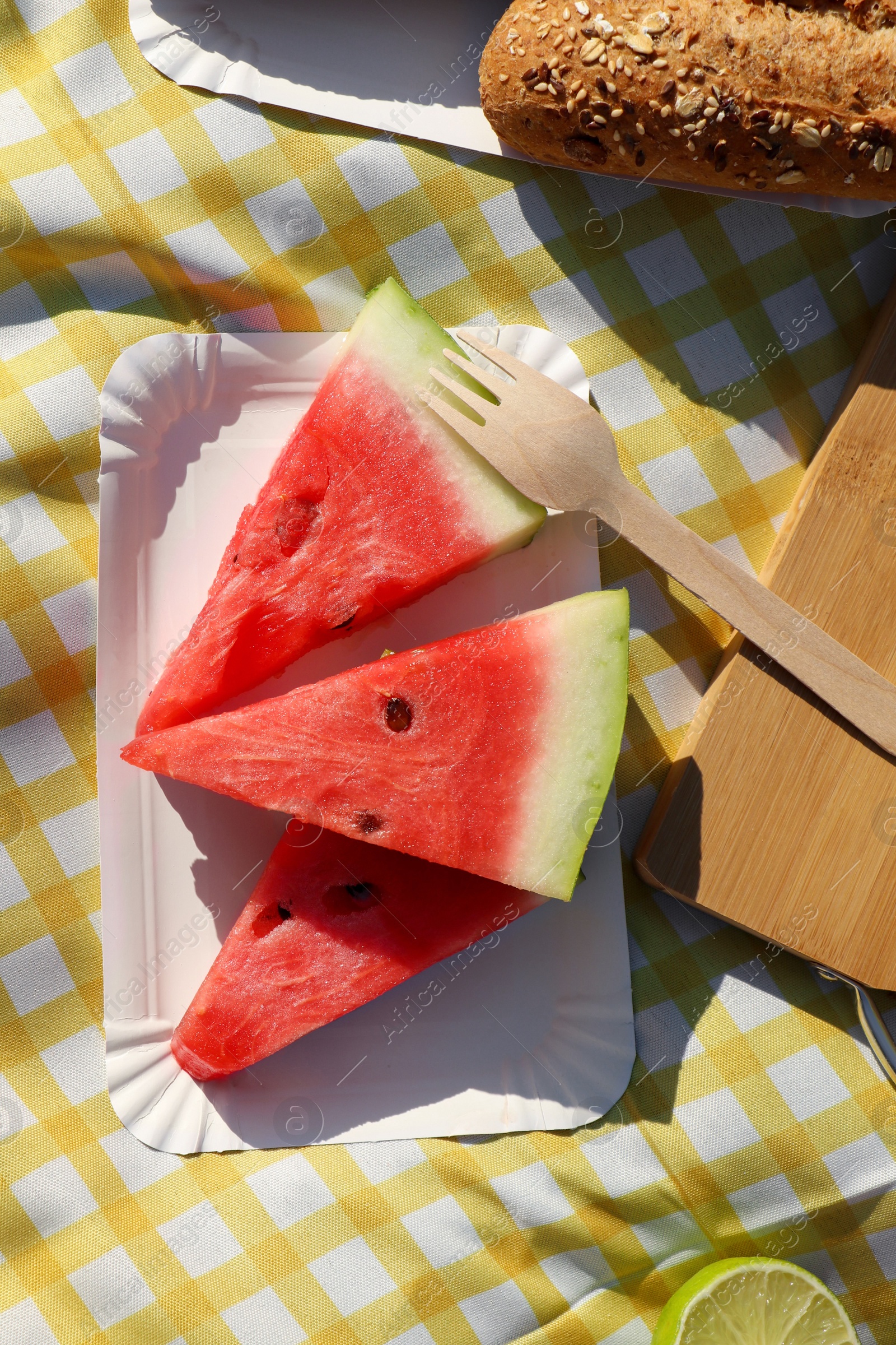 Photo of Delicious watermelon and bread on picnic blanket, flat lay