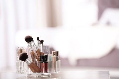 Photo of Organizer with makeup cosmetic products on table indoors. Space for text