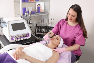 Young woman undergoing cosmetic procedure in beauty salon. Microcurrent therapy