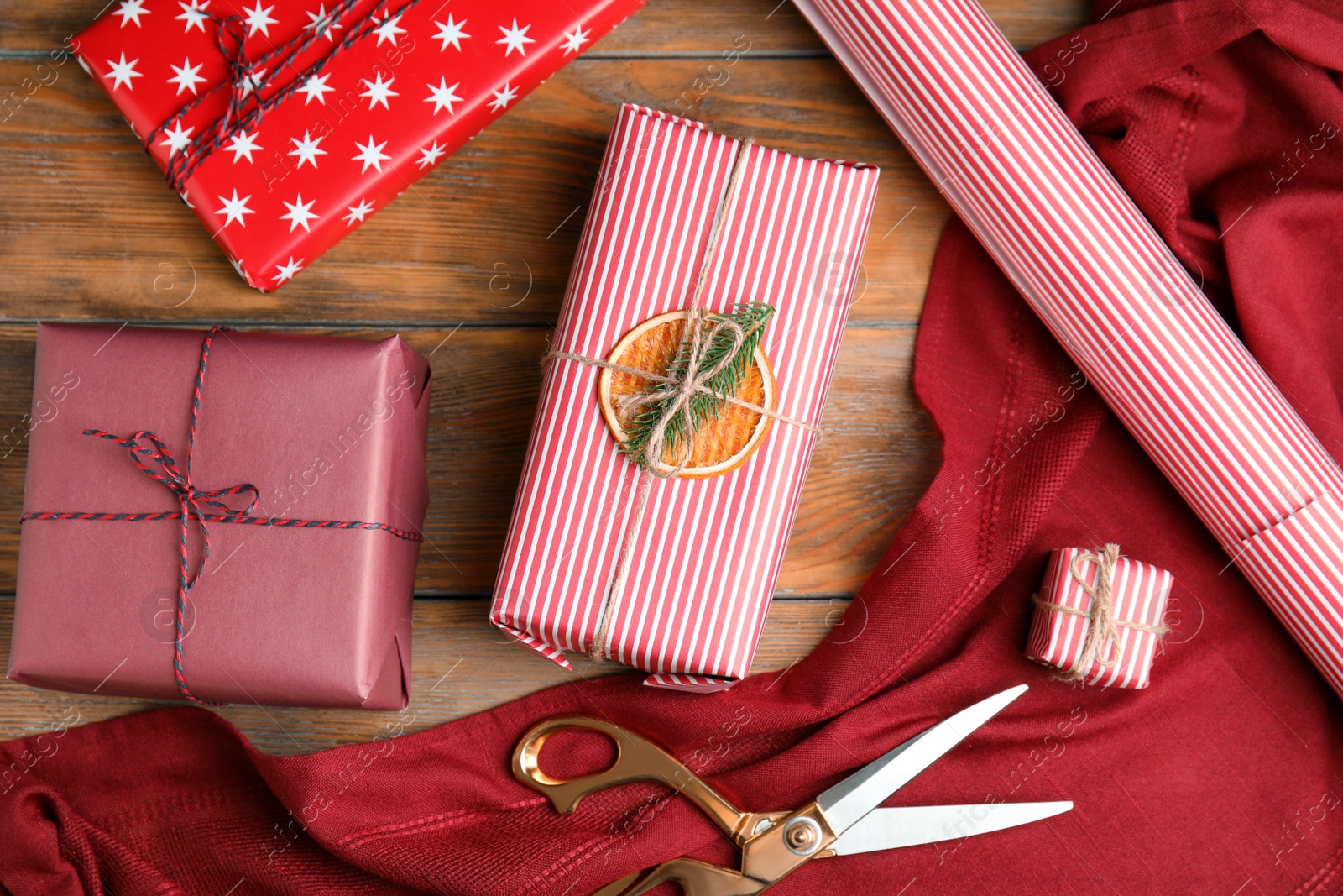 Photo of Flat lay composition of Christmas gift boxes wrapped with color paper on wooden table