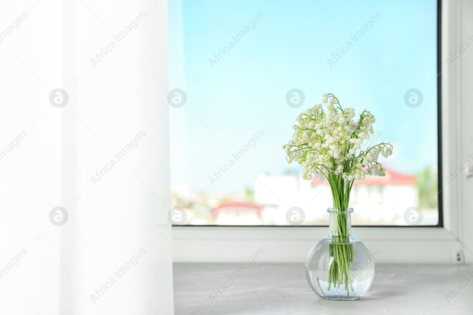 Photo of Beautiful lily of the valley bouquet in vase on windowsill, space for text