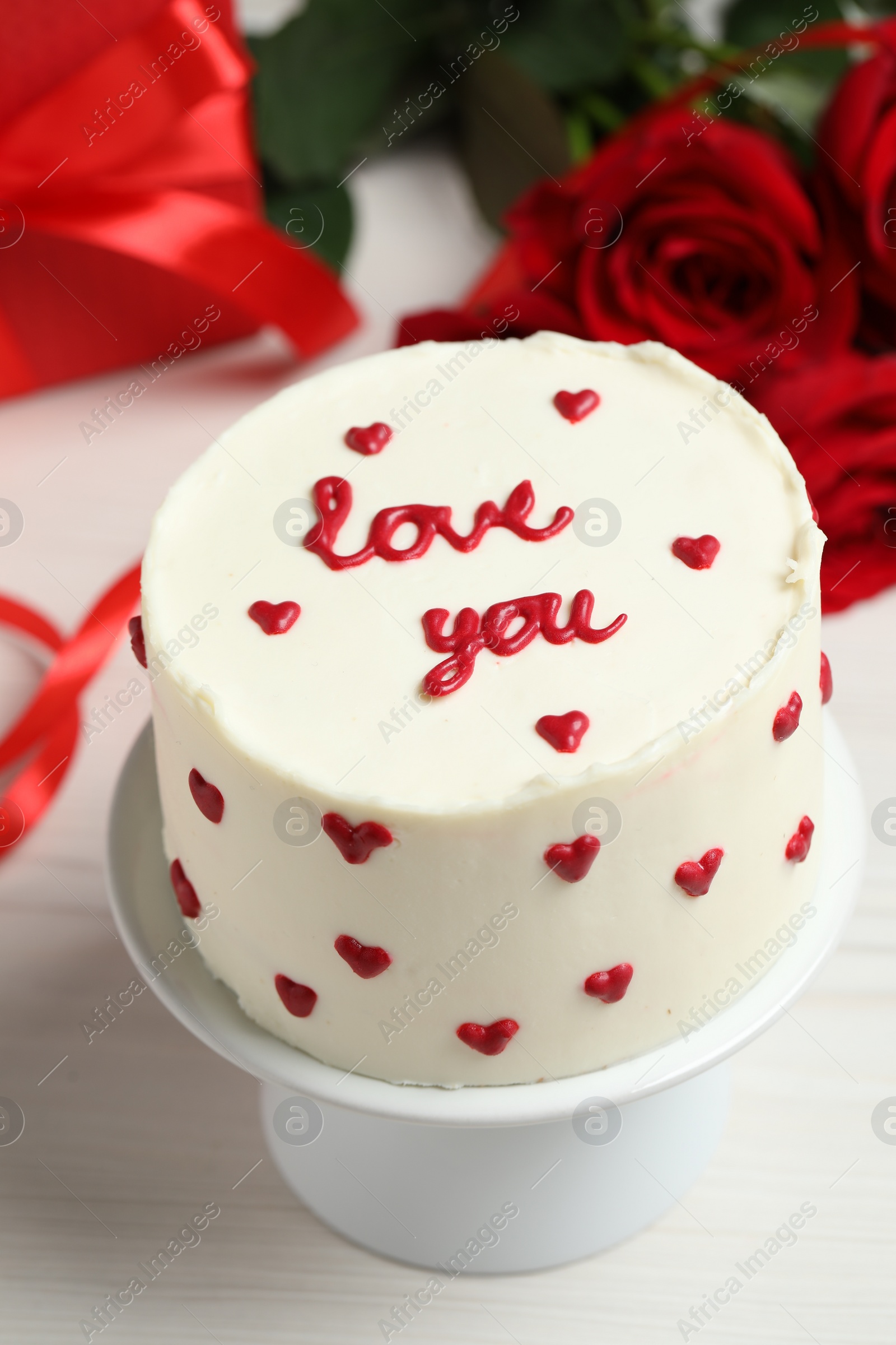 Photo of Bento cake with text Love You on white wooden table, closeup. St. Valentine's day surprise