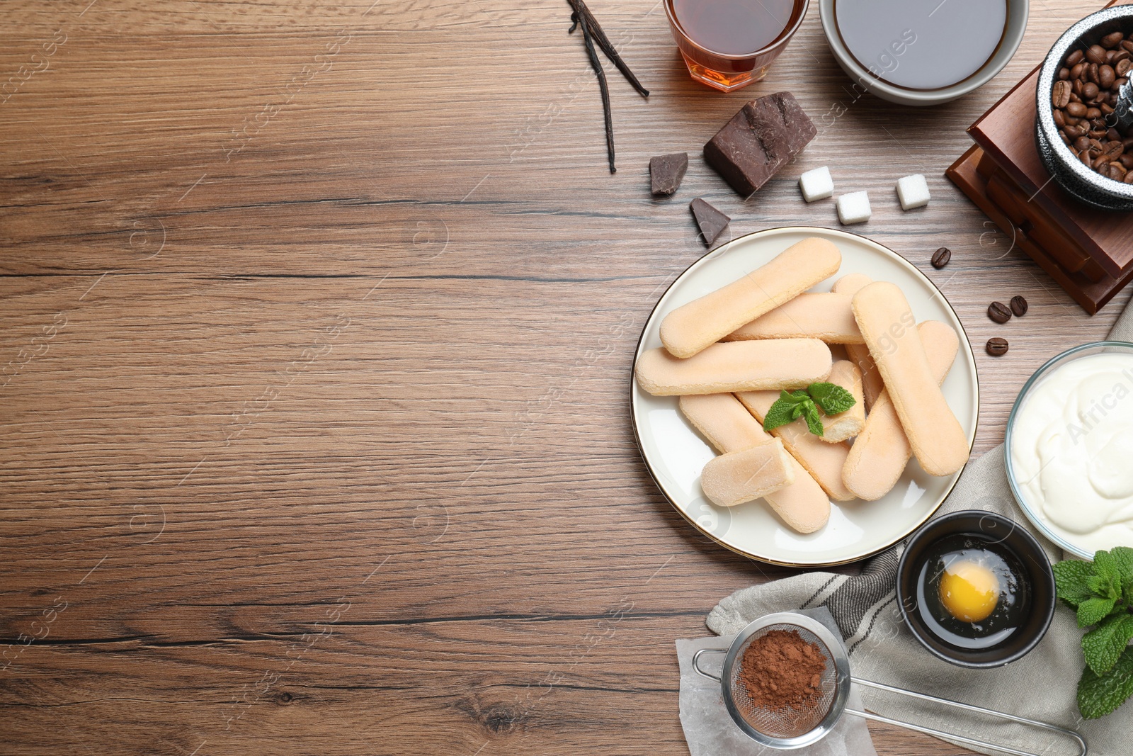 Photo of Flat lay composition with tiramisu ingredients on wooden table, space for text