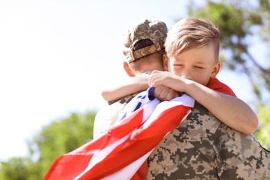 American soldier with his son outdoors. Military service