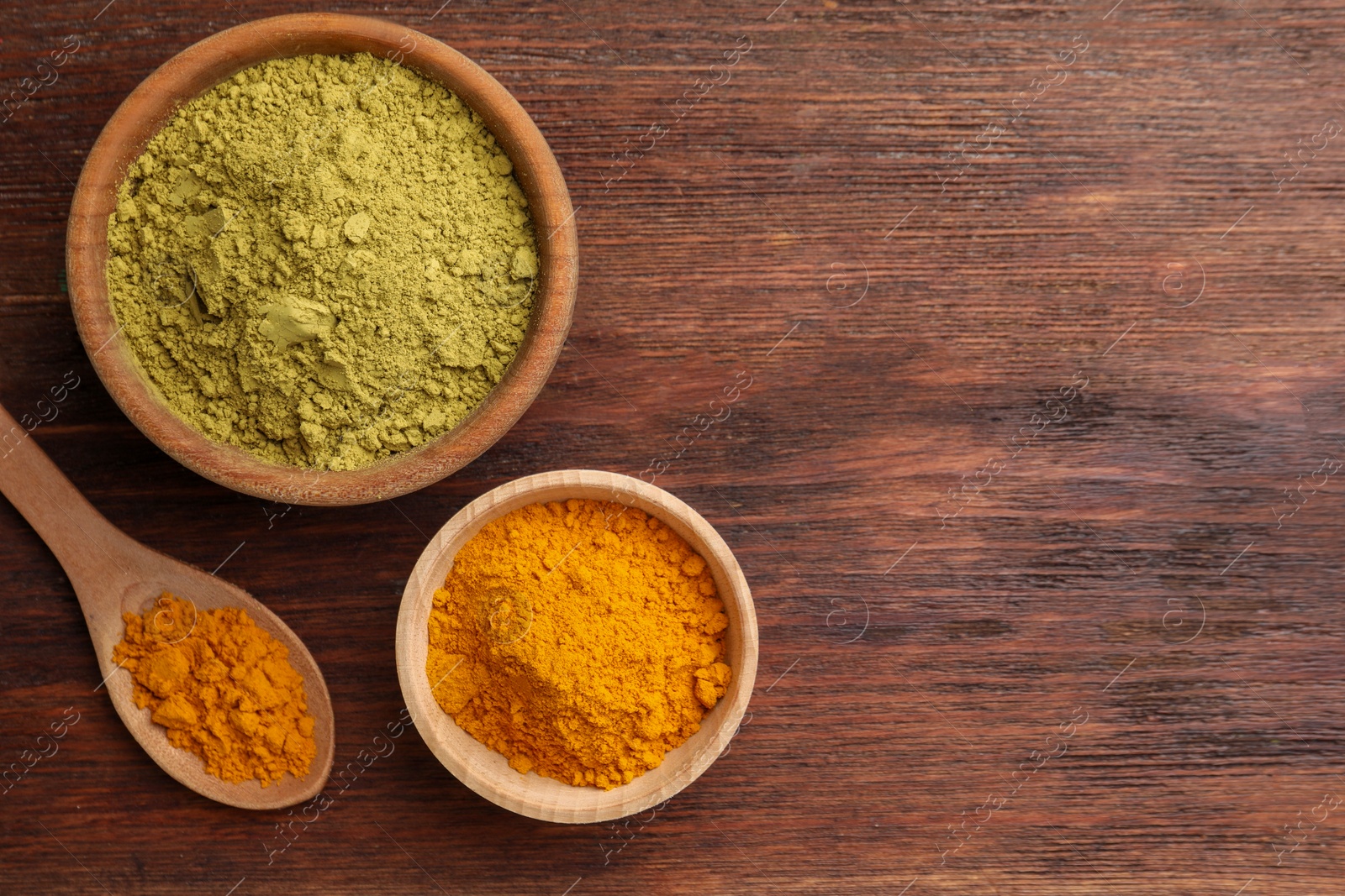 Photo of Henna and turmeric powder on wooden table, flat lay. Space for text