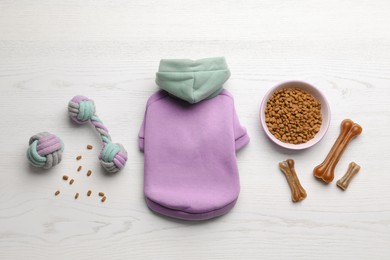 Photo of Flat lay composition with clothes, food and accessories for dog on white wooden table