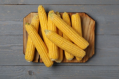 Photo of Corn cobs on grey wooden table, top view