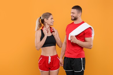Photo of Athletic people with headphones and towel on yellow background