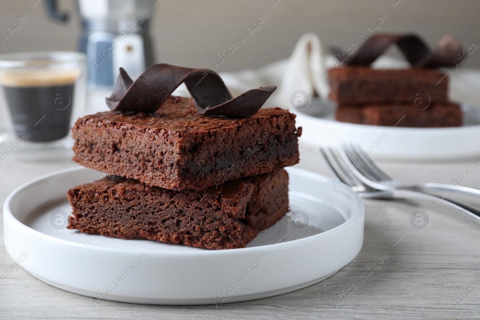 Photo of Delicious chocolate brownies served on white wooden table