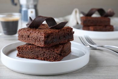 Delicious chocolate brownies served on white wooden table