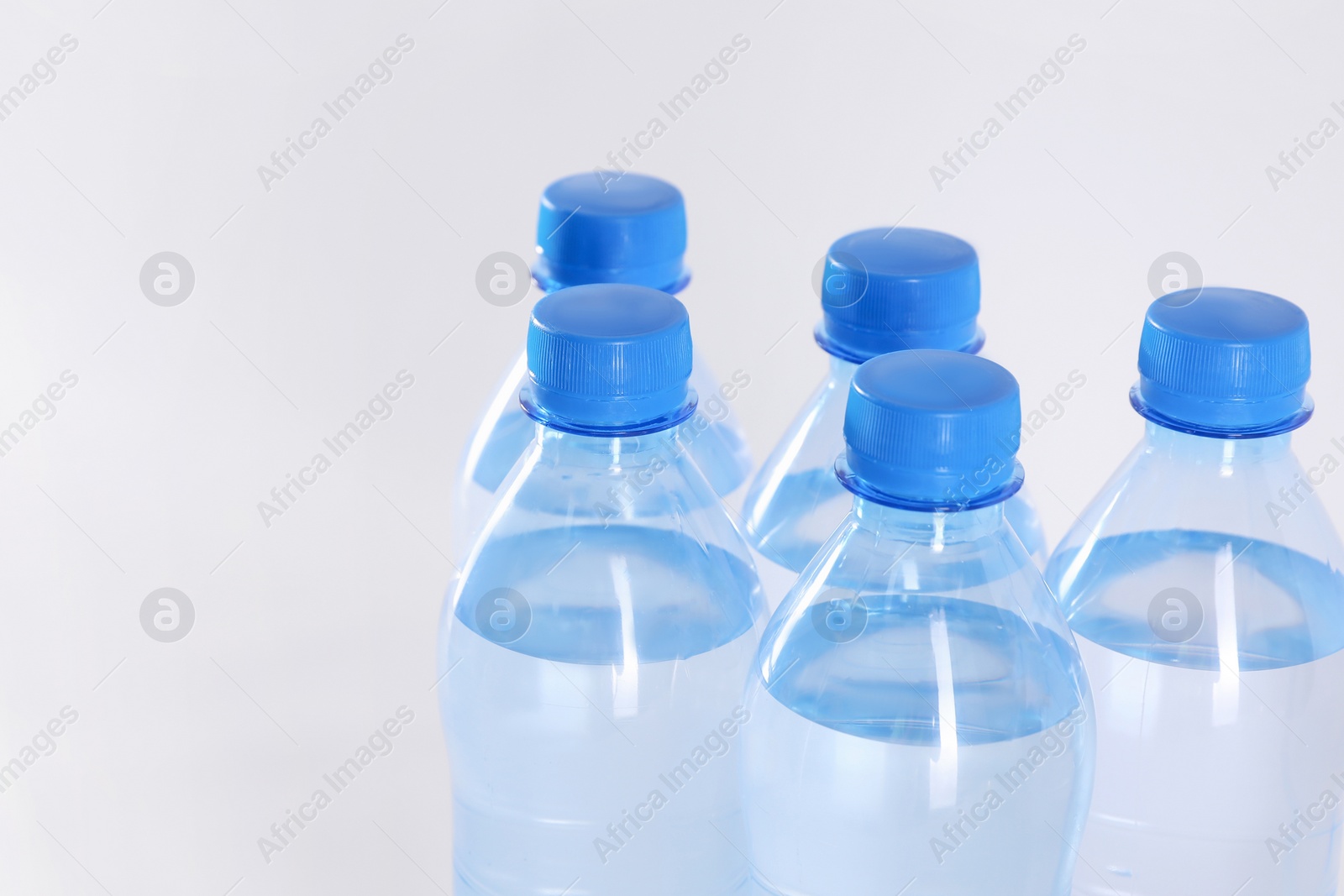 Photo of Plastic bottles with pure water on white background, closeup