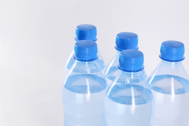 Plastic bottles with pure water on white background, closeup