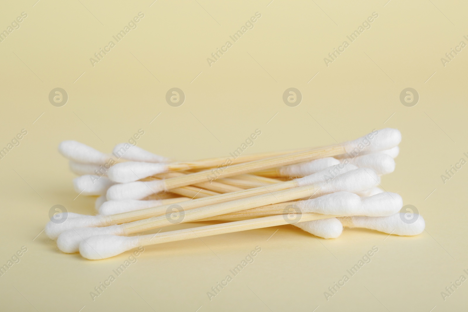 Photo of Many wooden cotton buds on beige background