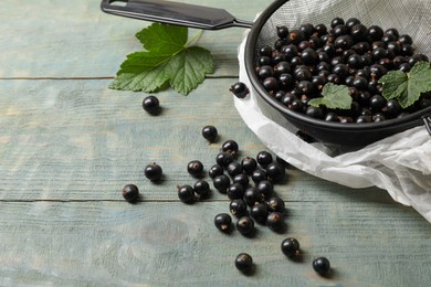 Photo of Ripe blackcurrants and leaves on wooden rustic table. Space for text