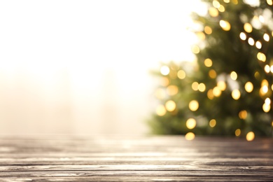 Photo of Empty table and blurred fir tree with yellow Christmas lights on background, bokeh effect. Space for design