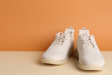 Photo of Pair of stylish sport shoes on beige background. Space for text