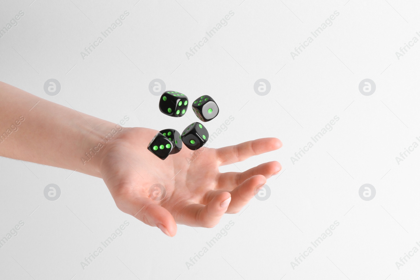 Photo of Woman throwing game dices on white background, closeup