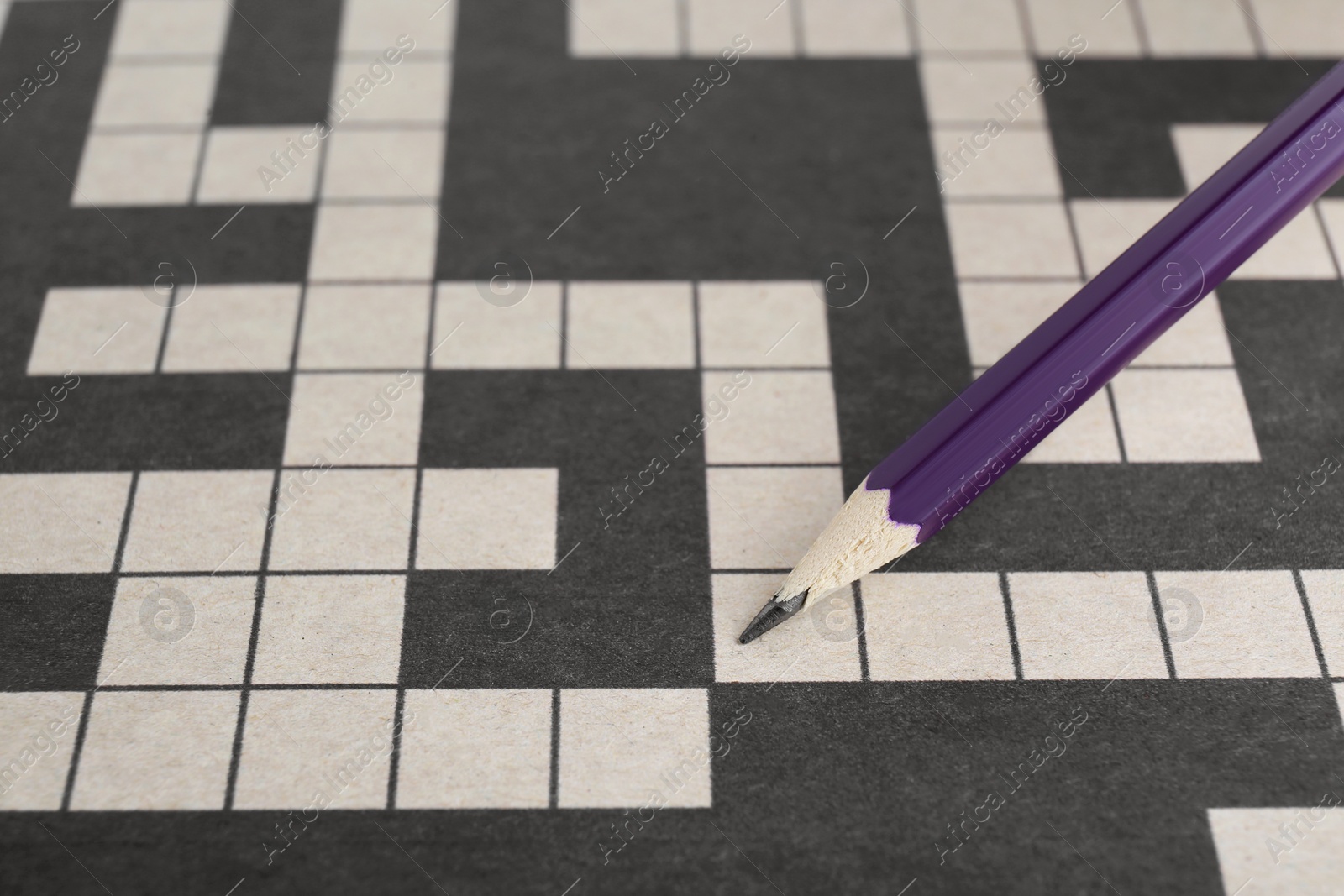 Photo of Pencil and blank crossword, closeup. Space for text