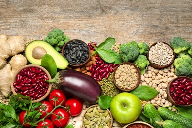 Different vegetables, seeds and fruits on wooden table, flat lay with space for text. Healthy diet