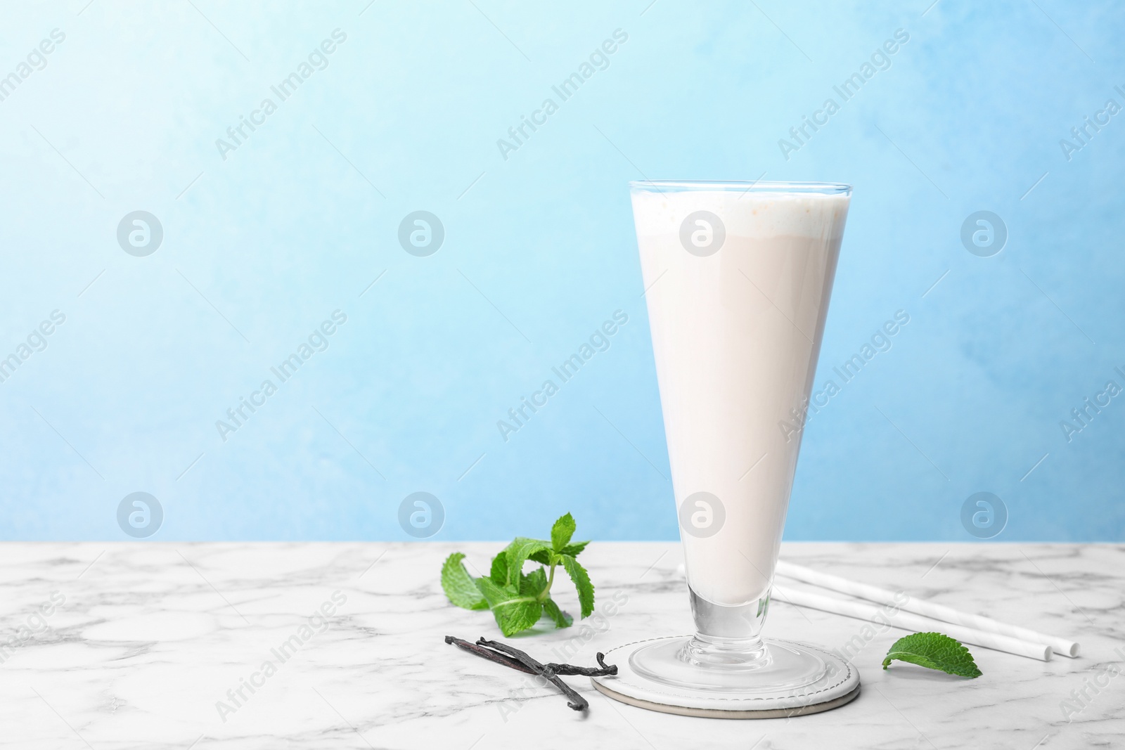 Photo of Glass with vanilla milk shake on table