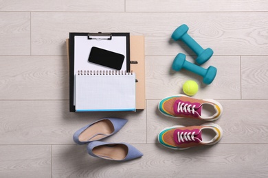 Flat lay composition with business supplies and sport equipment on white wooden floor. Concept of balance between work and life