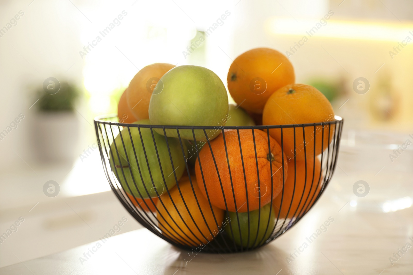 Photo of Bowl of delicious fresh fruits on table in kitchen