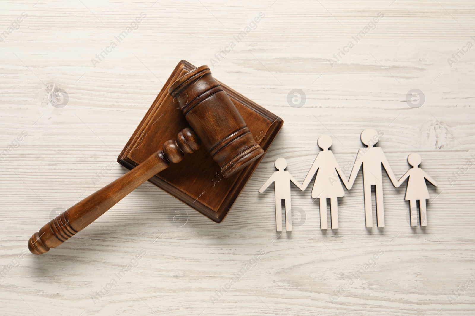 Photo of Law concept. Gavel and figures of parents with children on white wooden table, top view