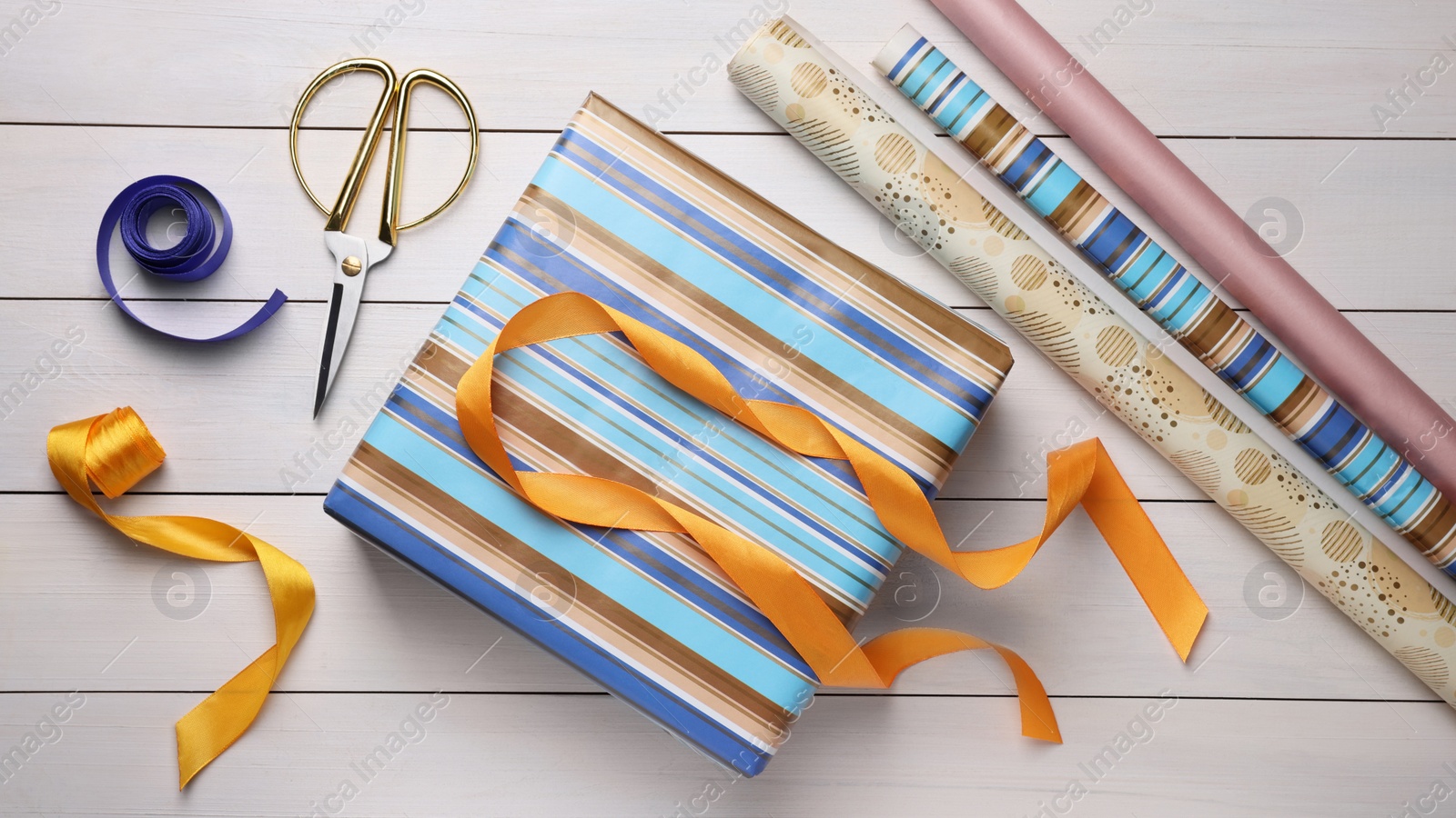 Photo of Flat lay composition with beautifully wrapped gift box on wooden table