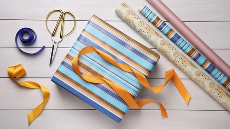 Photo of Flat lay composition with beautifully wrapped gift box on wooden table