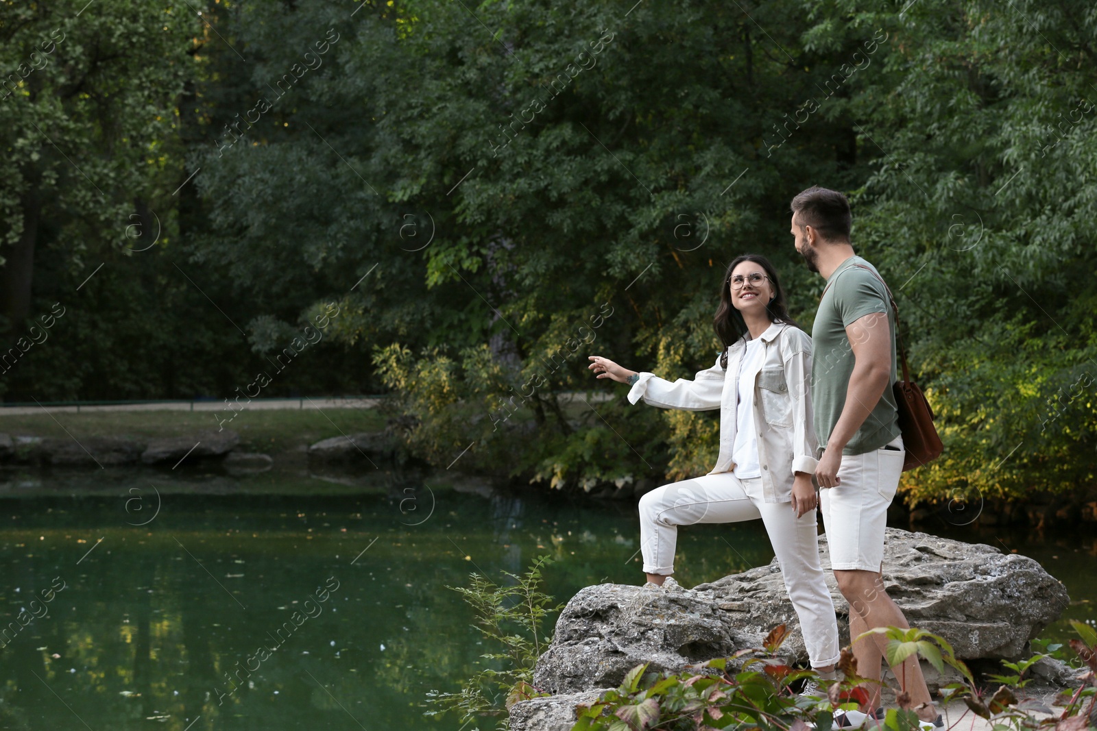 Photo of Lovely couple spending time together near pond in nature reserve