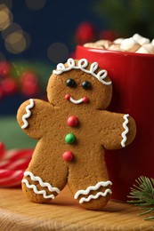 Photo of Tasty gingerbread man cookie and cocoa with marshmallows on table, closeup