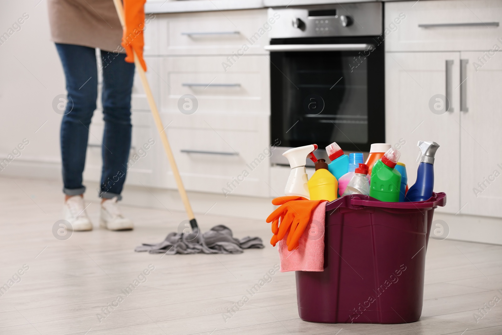 Photo of Set of cleaning supplies on floor in kitchen. Space for text