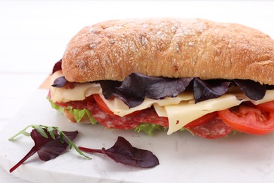 Photo of Delicious sandwich with cheese, salami, tomato on board, closeup