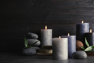 Spa composition with burning candles on table, space for text