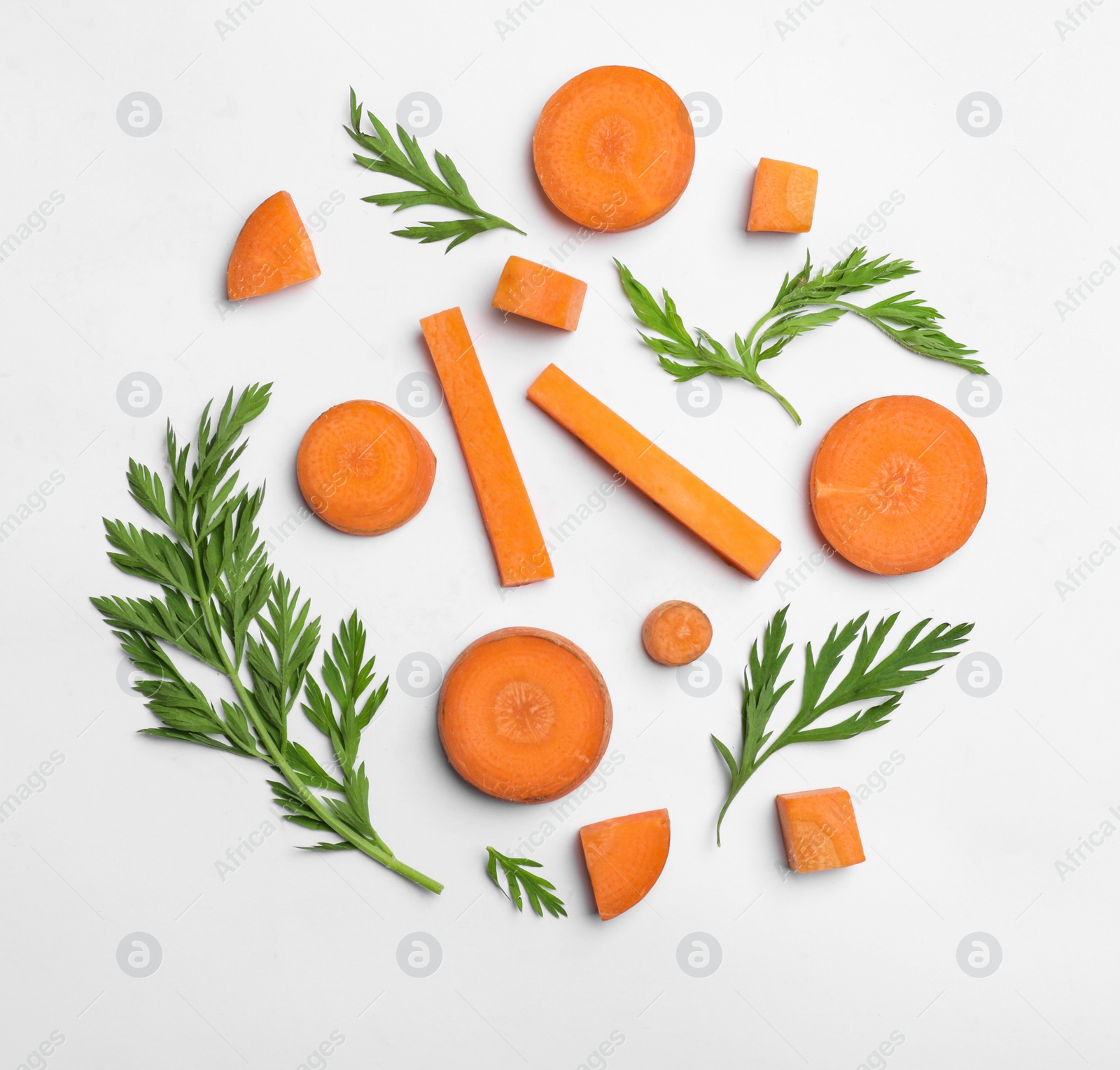 Photo of Cut carrot and leaves isolated on white, top view