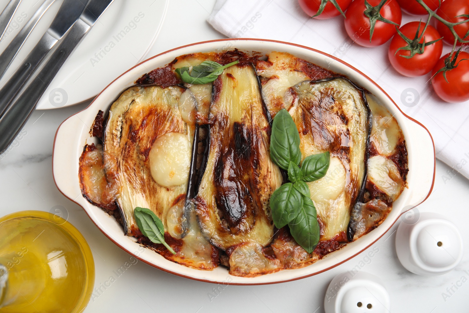 Photo of Delicious eggplant lasagna in baking dish on white marble table, flat lay