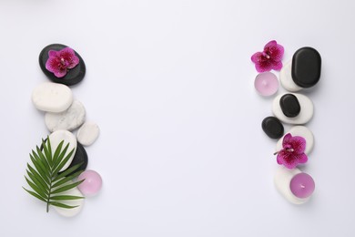 Photo of Flat lay composition with spa stones, palm tree leaf and flowers on white background, space for text