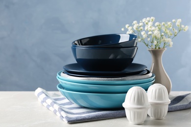 Photo of Different dishware and vase with flowers on table