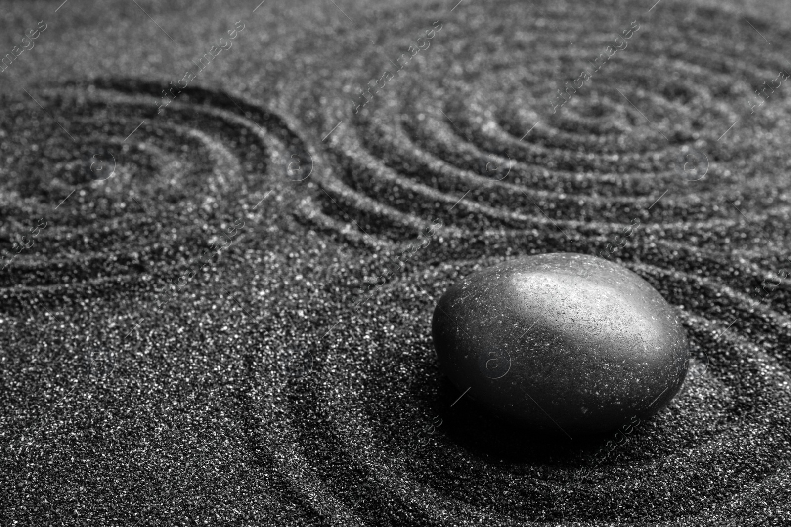 Photo of Black sand with stone and beautiful pattern. Zen concept