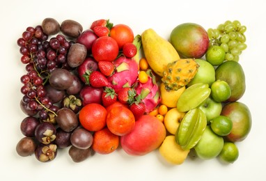 Photo of Assortment of fresh exotic fruits on white background, flat lay