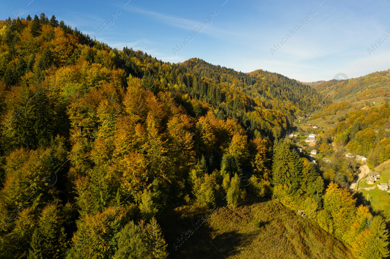 Image of Aerial view of beautiful mountain forest and village on autumn day