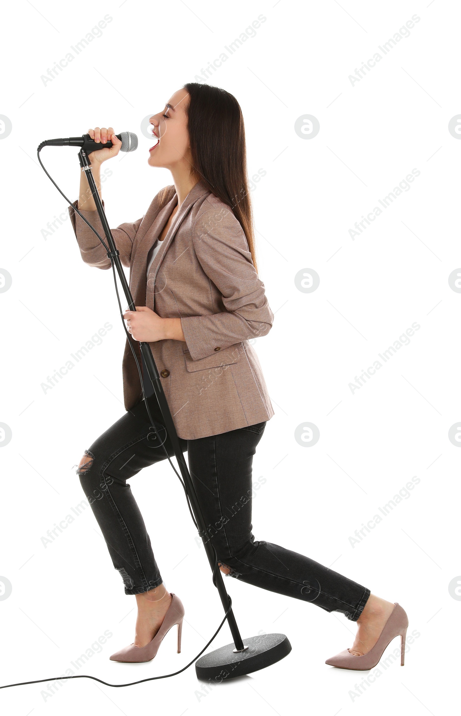 Photo of Young stylish woman singing in microphone on white background