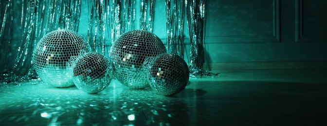 Photo of Shiny disco balls indoors, toned in dark green. Space for text