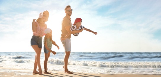 Image of Happy family having fun on sandy beach near sea, space for text. Banner design